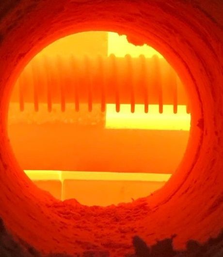 Glowing elements inside an industrial furnace chamber, seen through the door.